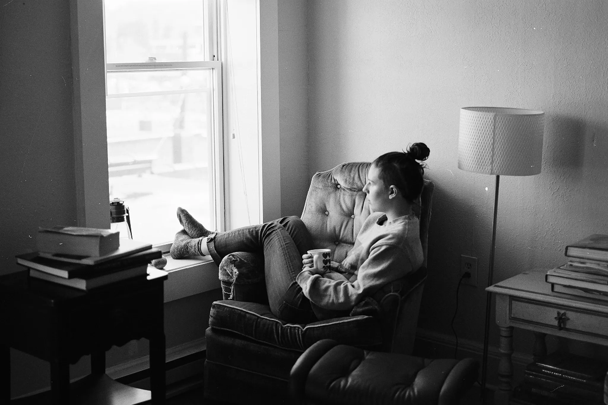 Erin drinks some tea while staring out a window.