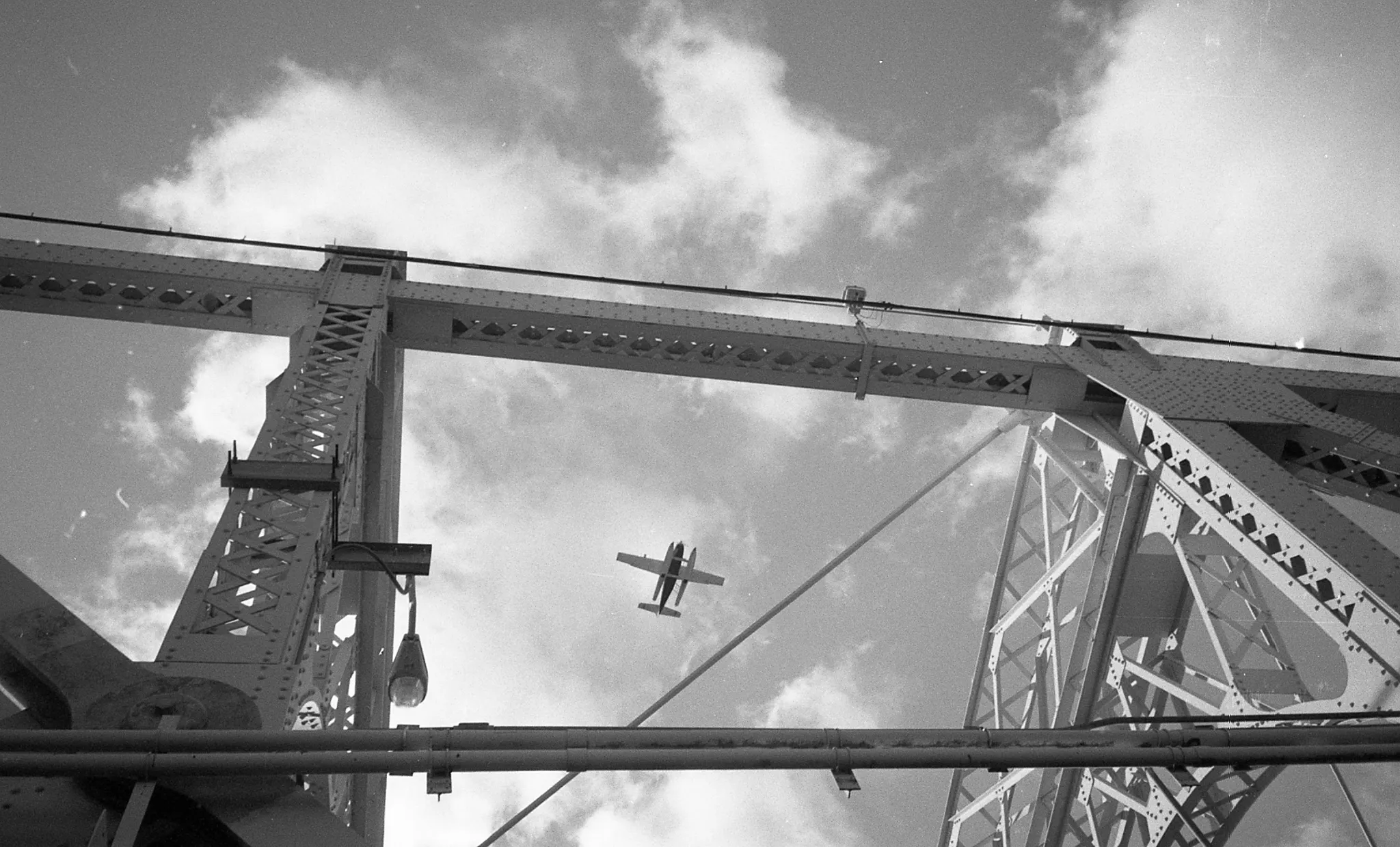 A plane flies over a bridge in New York City.