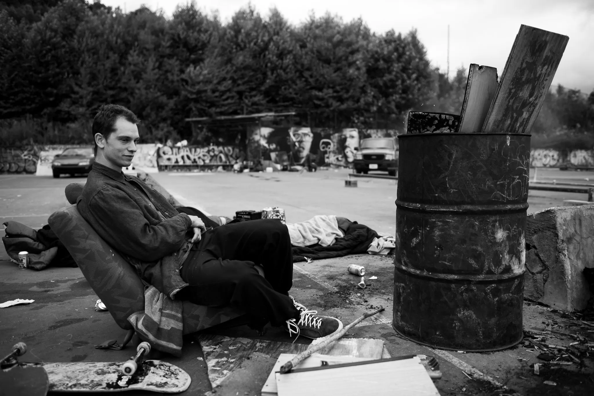 Robert sits by a fire on the last day celebration of a skate park to be demolished.